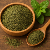 برگهای خشک نعنا فلفلی طبیعی روی میز چوبی با برگهای تازه نعنا و فنجان چای گیاهی در پسزمینه